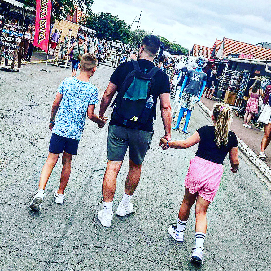Joël met zijn kinderen van achteren tijdens een vakantie