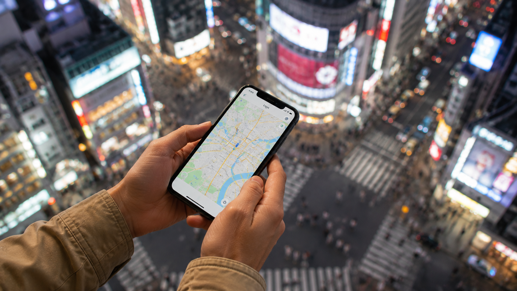 Handen houden een telefoon met kaart vast boven een straat in Tokio